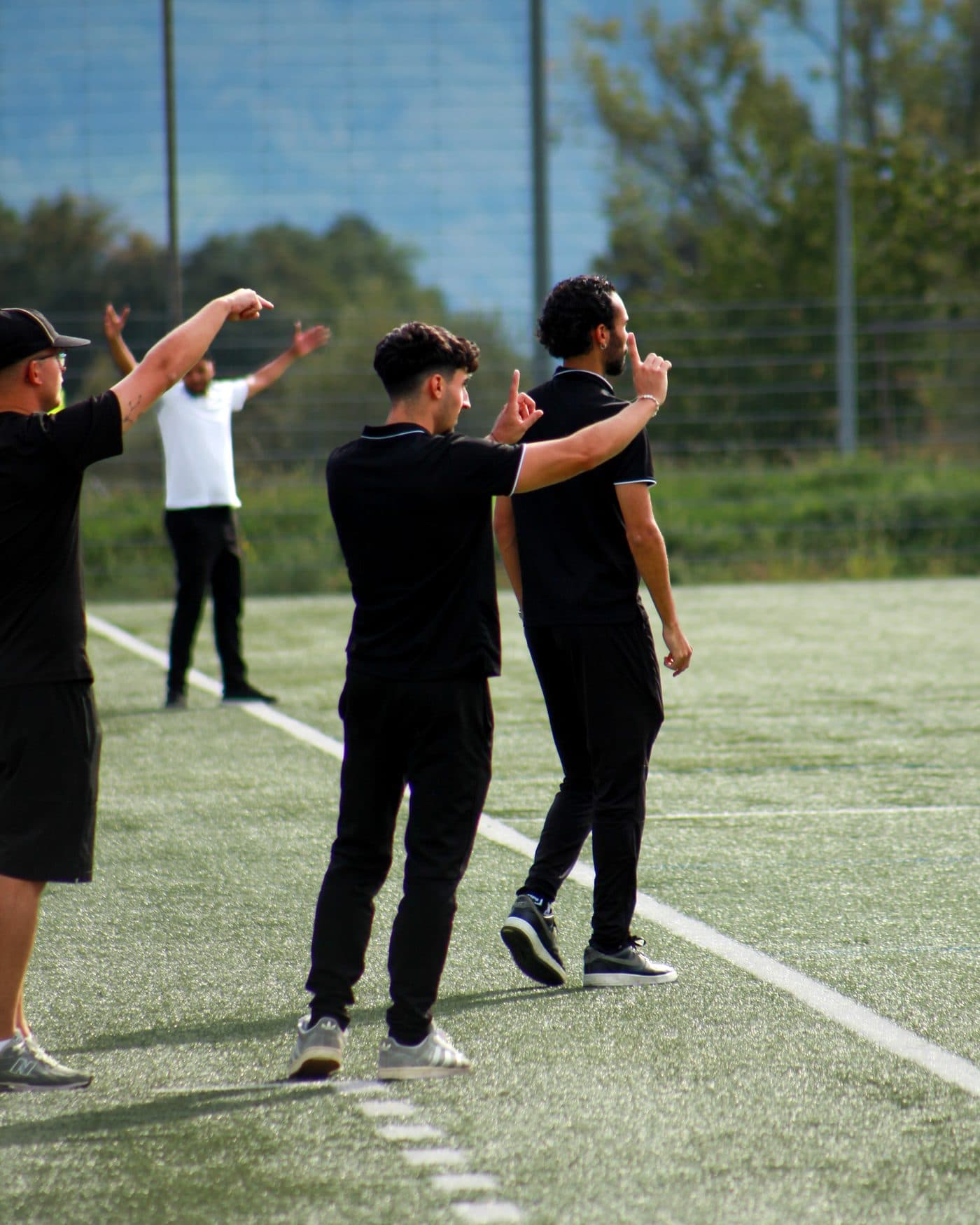 Trois entraîneurs au bord du terrain donnent leurs consignes aux joueurs